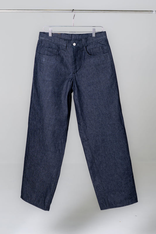 Blue jeans hanging on a rack against a white background