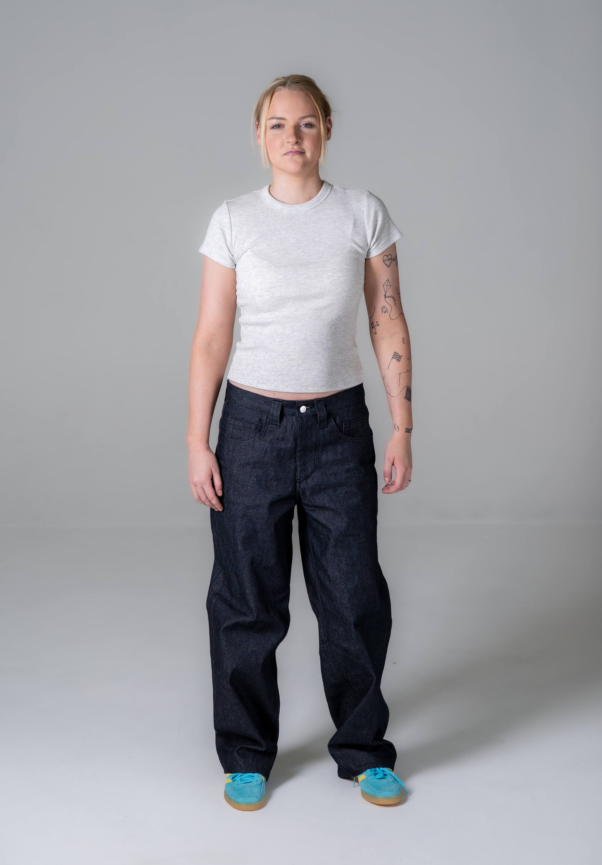 Person wearing a white t-shirt and black pants on a gray background