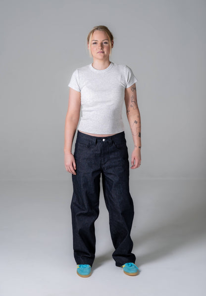 Person wearing a white t-shirt and black pants on a gray background
