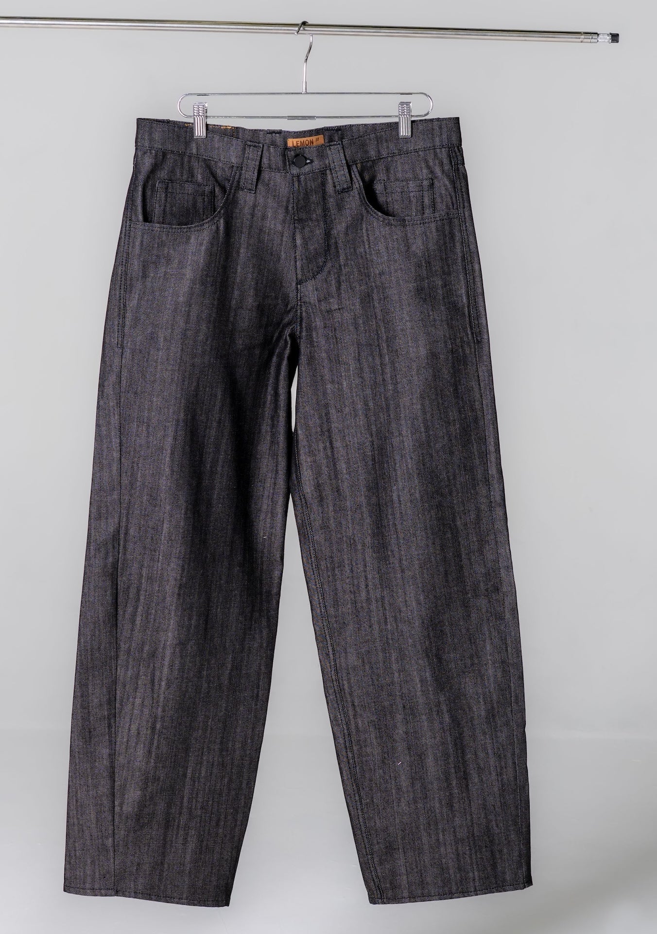 Dark denim jeans hanging on a white background