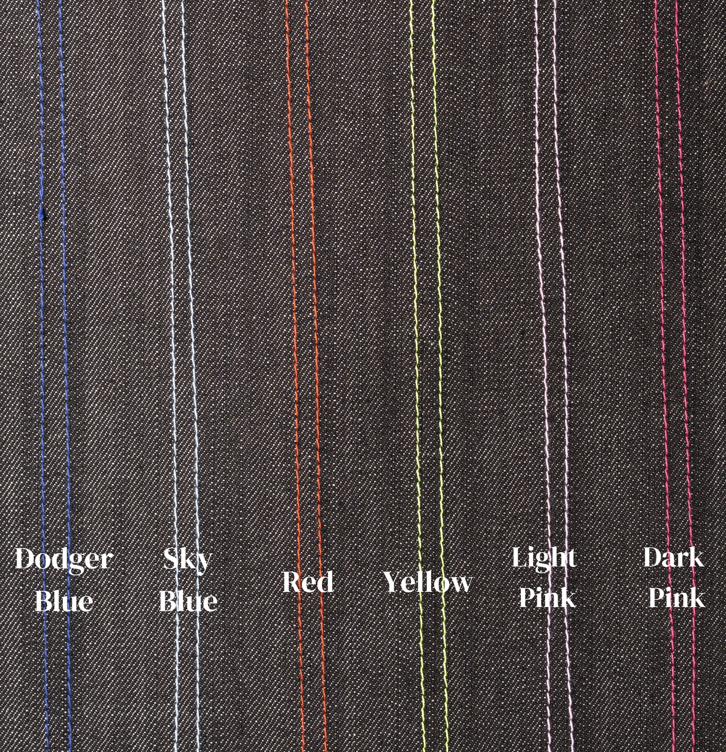 Close-up of gray fabric with colored stitching labels on a gray background