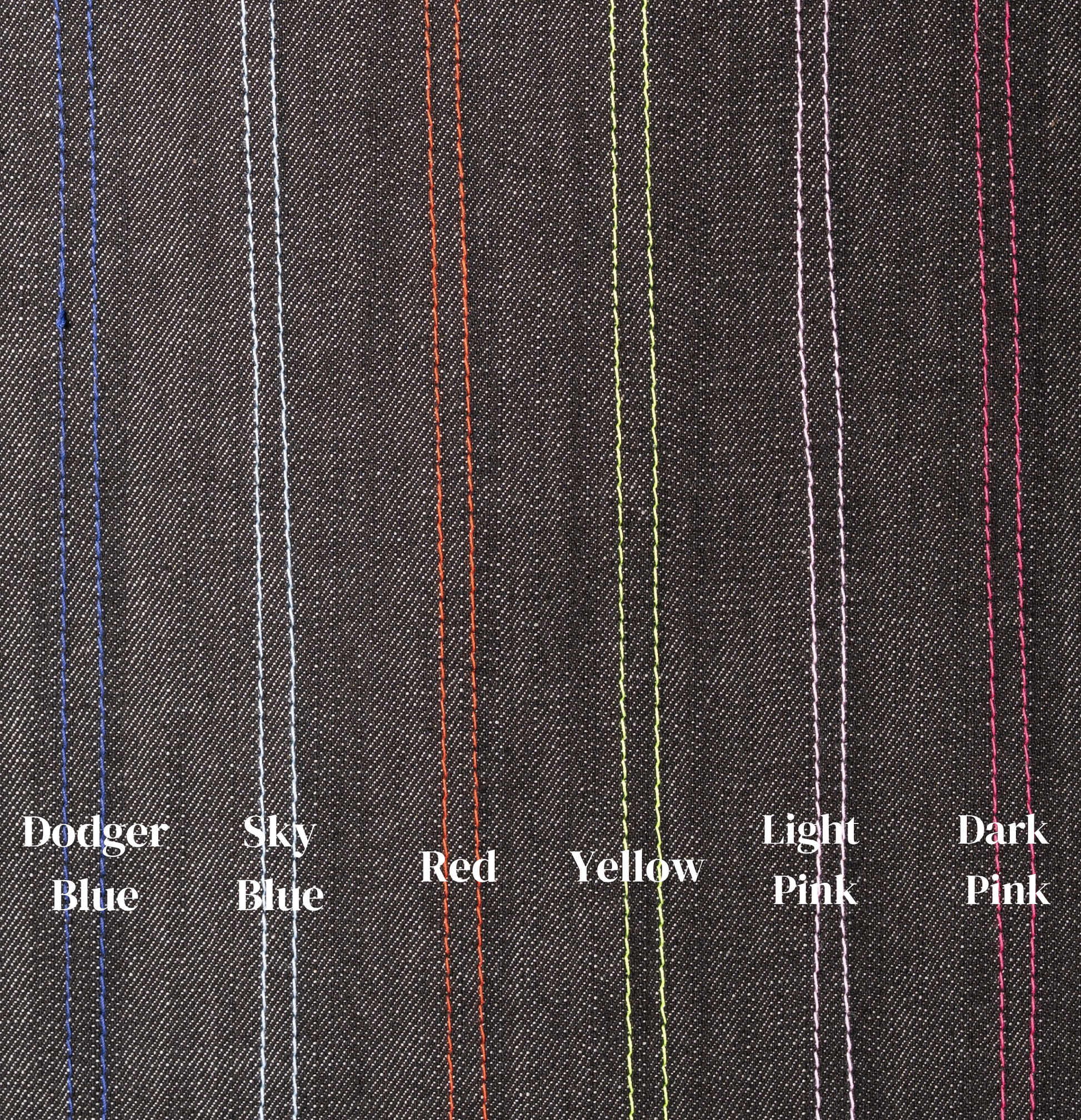 Close-up of gray fabric with colored stitching labels on a gray background