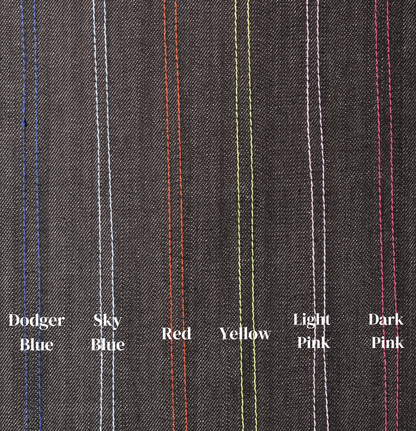 Close-up of gray fabric with colored stitching labels on a gray background