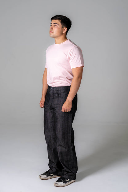 Person wearing a pink t-shirt and black pants against a gray background