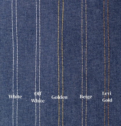 Close-up of denim fabric with colored stitching labels on a blue background