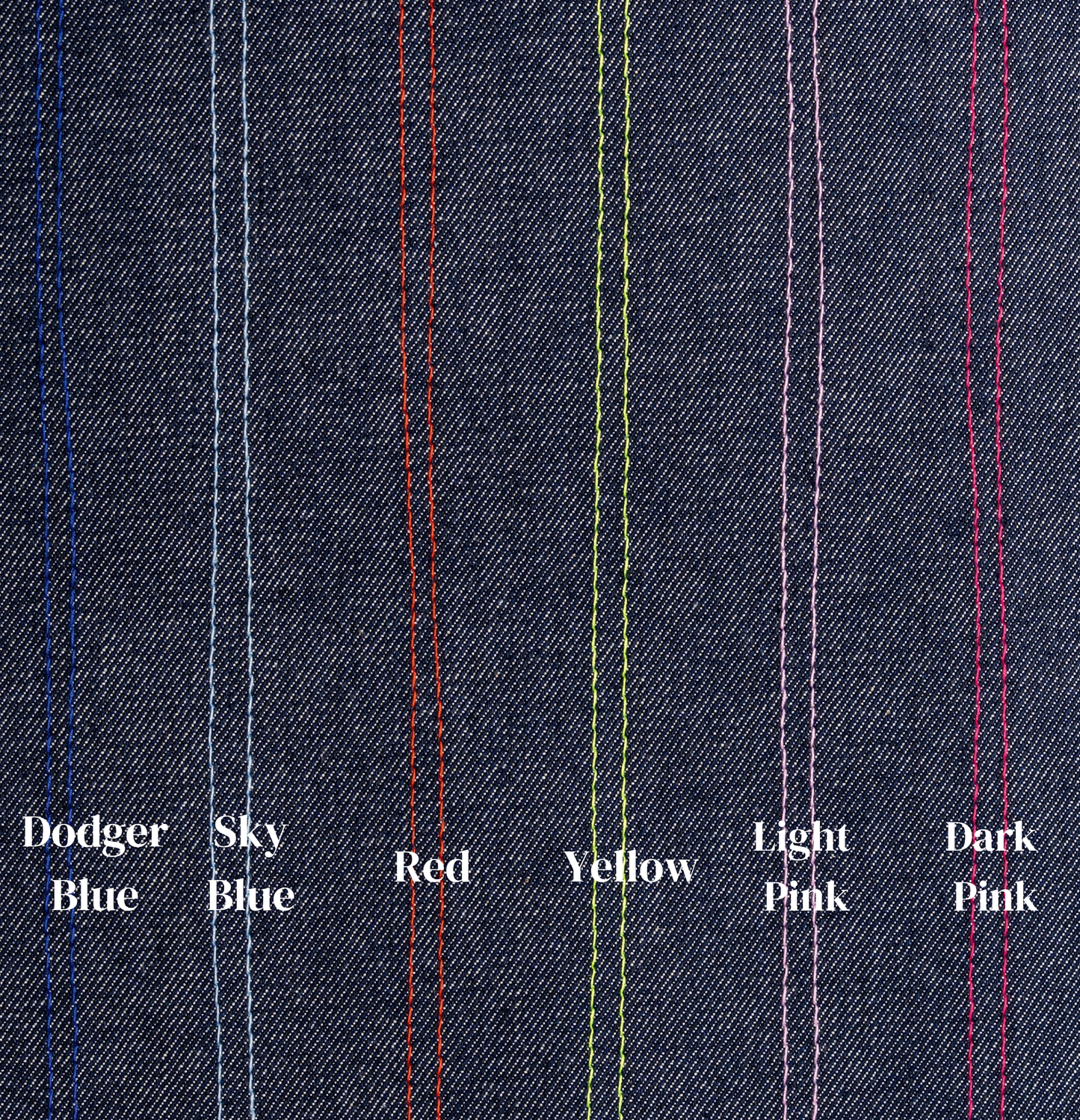 Close-up of denim fabric with colored stitching labels on a dark blue background