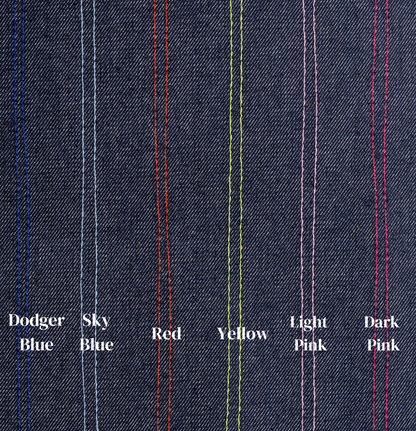 Close-up of denim fabric with colored stitching labels on a dark blue background