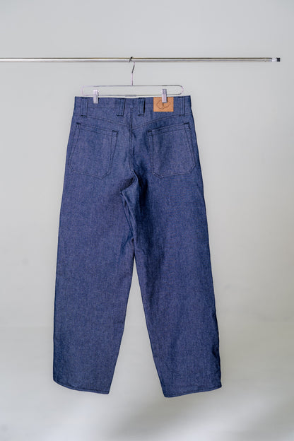 Blue denim pants hanging on a white background